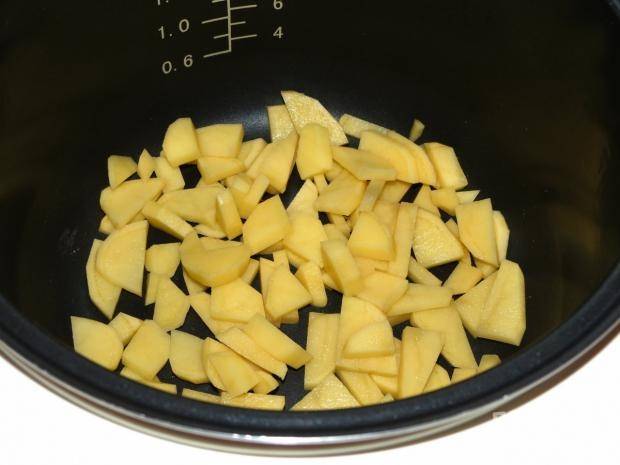 Картофель помойте, почистите и некрупно нарежьте. Выложите кусочки в чашу мультиварки.