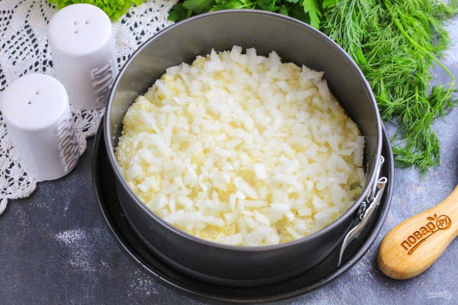 Отожмите замаринованный лук от жидкости и разложите на картофельном слое. Нарежьте маслины, оливки и выложите на лук (это по желанию).