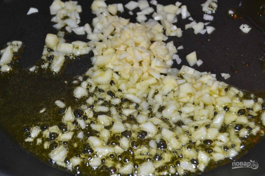3.	Разогрейте сковороду с 2-мя столовыми ложками оливкового масла на среднем огне, добавьте в нее чеснок и готовьте полминуты.