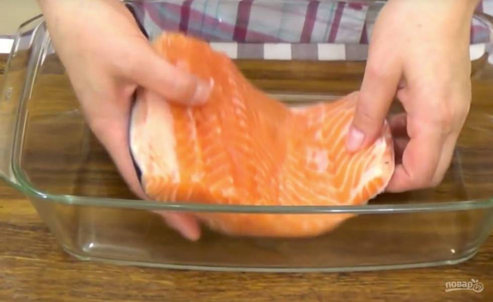 Часть промытого и обсушенного филе рыбки выложите в форму.
