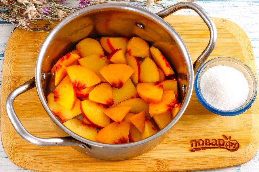 Персики промойте в воде, разрежьте пополам и  удалите косточку. Нарежьте мякоть ломтиками в кастрюлю или другую емкость, в которой будете варить компот. Если фрукты мелкие, то используйте 2-3 плода.