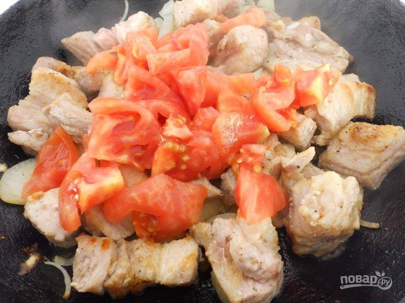 Пока готовится каша, на сковороде обжарьте мясо до румяной корочки. Затем добавьте лук, обжарьте 5-7 минут. После добавьте помидоры и соль.
