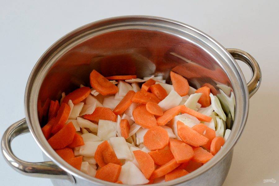 Нарежьте капусту крупными кусочками. Морковь очистите и нарежьте кружочками. 

