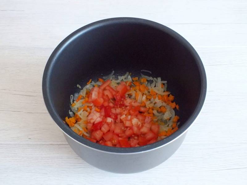 Когда овощи станут мягкими, добавьте нарезанный мелкими кубиками помидор и обжаривайте в течение 5-7 минут. Помешивайте.