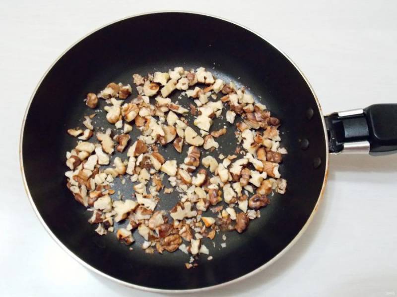 Грецкие орехи крупно порубите и обжарьте на сухой сковороде в течение 5 минут на медленном огне.
