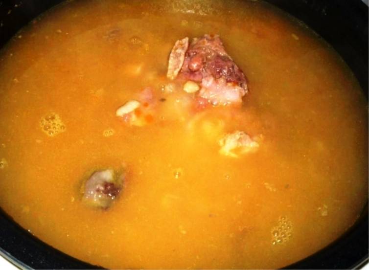 Залейте горячей водой. Установите режим "Суп", готовьте в течение 2 часов. При подаче добавьте в суп зелень и сметану. 