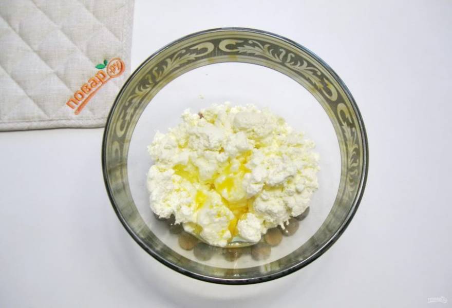 В миску выложите творог и добавьте яйца.