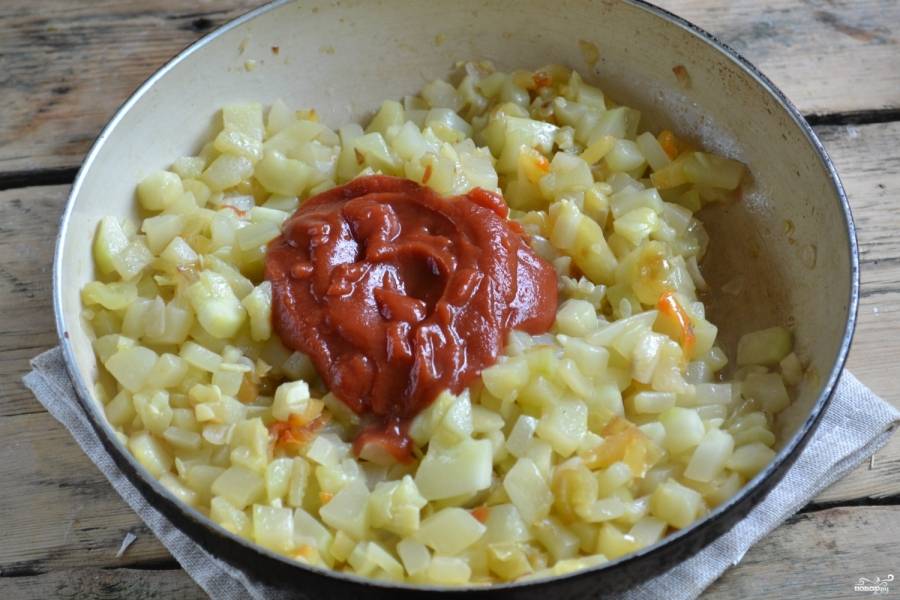 Положите в емкость к овощам томатную пасту и хорошенько размешайте.