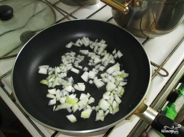 5. Выложите лук с чесноком на сковороду, обжарьте их пару минут до прозрачности. Очищенную морковь натрите на терке. 