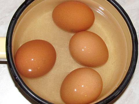 Вкрутую отвариваем яйца.