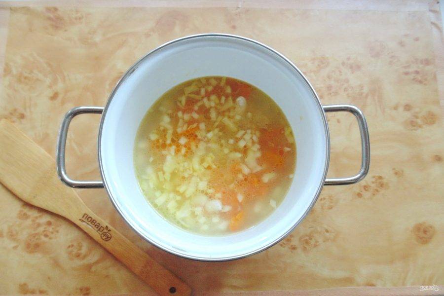 Обжаренные лук и морковь добавьте в кастрюлю с фасолью и бульоном.