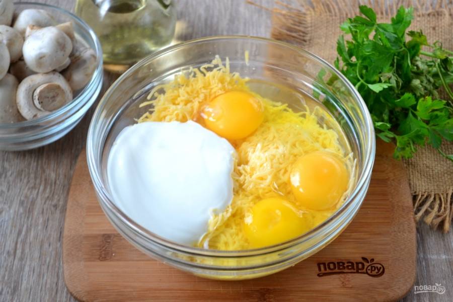 Сыр натрите на мелкой терке, добавьте к нему яйца, сметану и 1 ст. ложку оливкового масла, слегка посолите по вкусу.