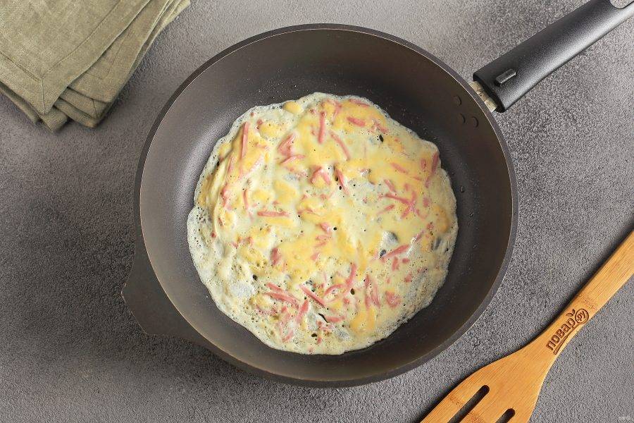 Сковороду разогрейте и смажьте маслом. Огонь должен быть чуть ниже среднего. Налейте в сковороду небольшое количество яичной массы и быстро распределите ее лопаткой по всей поверхности.