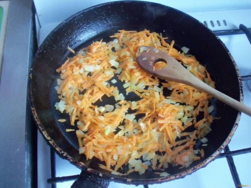 Затем почистите, помойте и натрите на крупной тёрке морковь. Добавьте её в сковороду, готовьте до мягкости продуктов.
