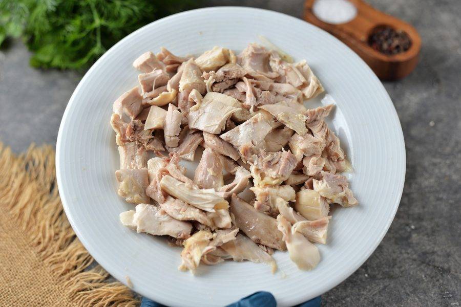 Извлеките куриный окорочок из бульона, отделите мясо от костей и кожи, мясо нарежьте мелким кубиком. 