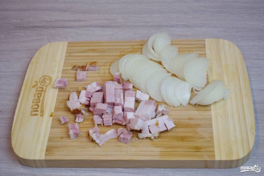 Пока картофель варится, нарежьте бекон кубиками, а репчатый лук полукольцами.
