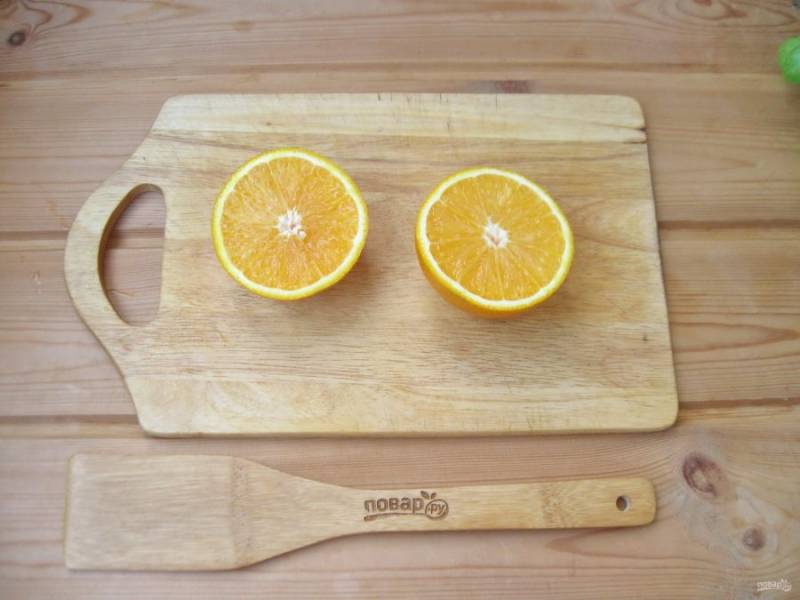 Апельсин вымойте и разрежьте на две половинки.