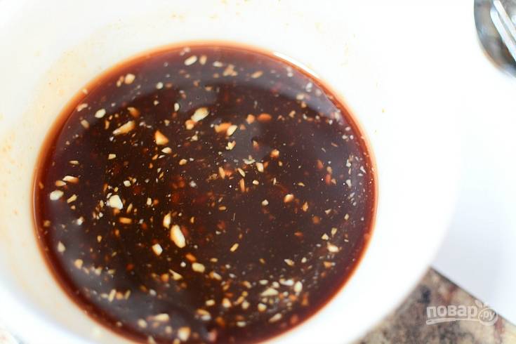 2. Сделайте соус. Мелко нарежьте лук и чеснок, а потом перемешайте их с маслом, соевым соусом, мёдом и кетчупом.