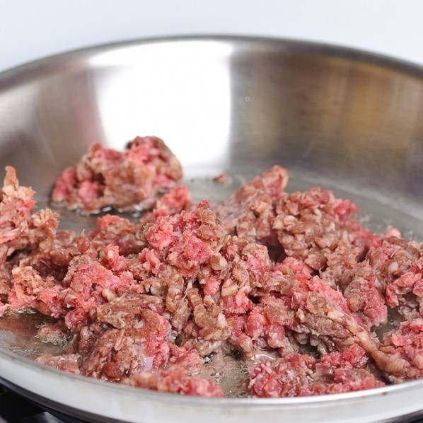Нагрейте сковороду до средне-высокой температуры, налейте масло и положите мясной фарш.
