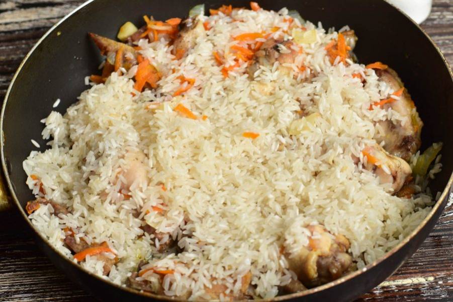 Выложите к овощам и мясу вымытый рис.