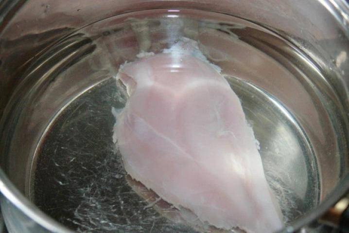 Для начала нужно сварить основу для солянки - бульон. Поставьте в кастрюле вариться промытое филе куриное, не забывайте снимать пенку. 