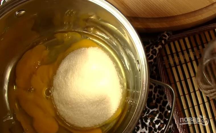 1. Для приготовления крема разбейте яйца в глубокую кастрюлю, добавьте сахар. Взбейте венчиком до пены. 