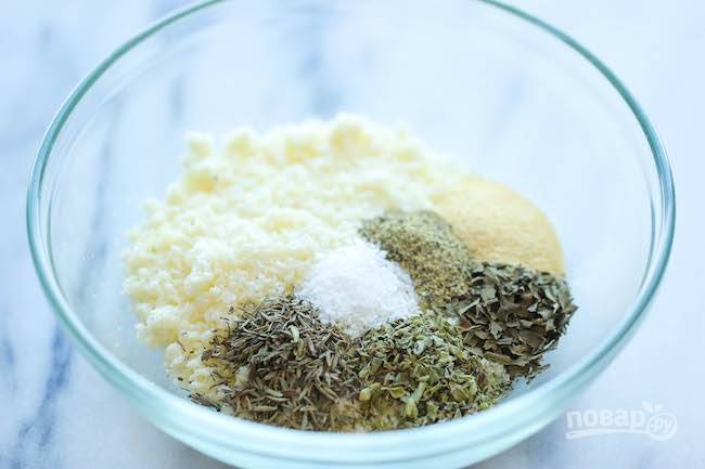 1.	В миску выложите тертый на мелкой терке пармезан, все сушеные травы, соль и черный молотый перец, чесночный порошок и перемешайте.