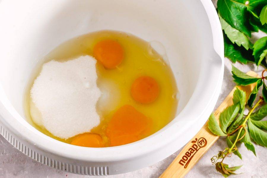 Куриные яйца вбейте в чашу кухонного комбайна или емкость миксера. Всыпьте туда же соль и сахарный песок. Взбейте в течение 3-4 минут. Разогрейте духовку до 180 градусов, если будете выпекать бисквит в ней.