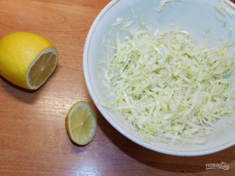 Капусту мелко нашинкуйте и сбрызните лимонным соком. Немного помните руками, чтобы капуста стала мягче.