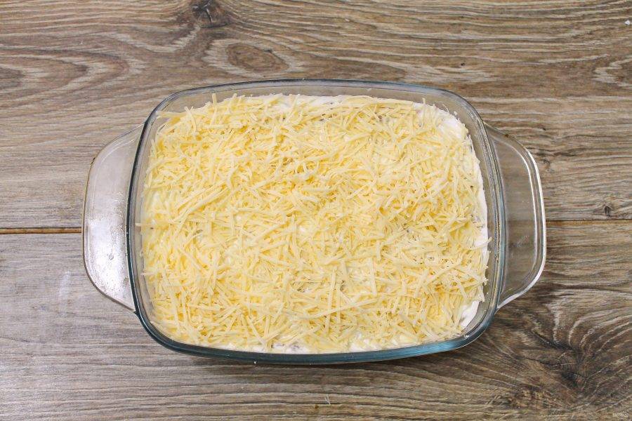 Сыр натрите на средней терке и посыпьте верх запеканки ровным слоем.