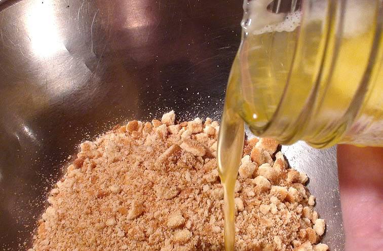 3. Растопленное масло добавить к крошке печенья и тщательно перемешать. С применением силы или подручных средств сформировать плотный корж на дне формы. 