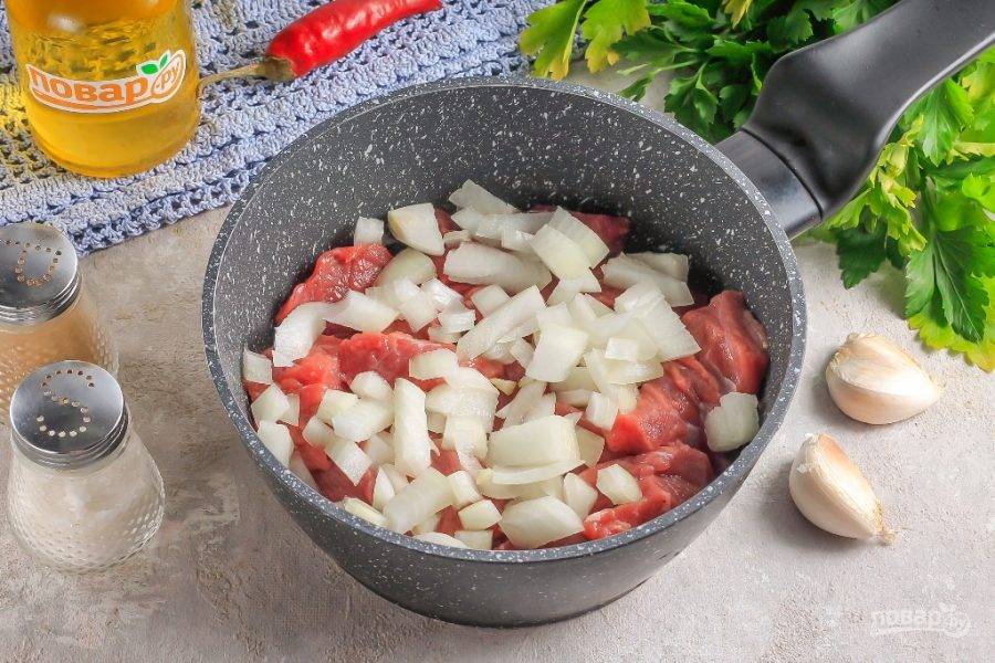 Нарежьте репчатый лук мелкими кубиками и добавьте в емкость к мясу. Тщательно все перемешайте и прожарьте примерно 10 минут. За это время говядина выпустит сок.