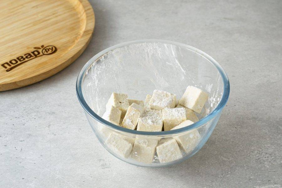Нарежьте тофу кубиками, обваляйте в крахмале.