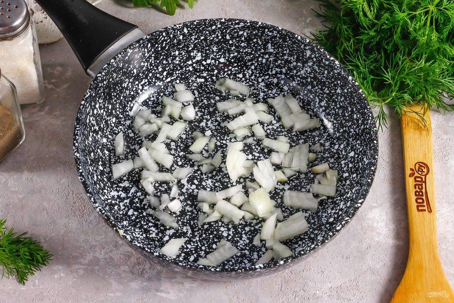 Очистите репчатый лук от кожуры и промойте в воде. Нарежьте мелкими кубиками и отпассеруйте его в растительном масле на сковороде в течение 3-5 минут.