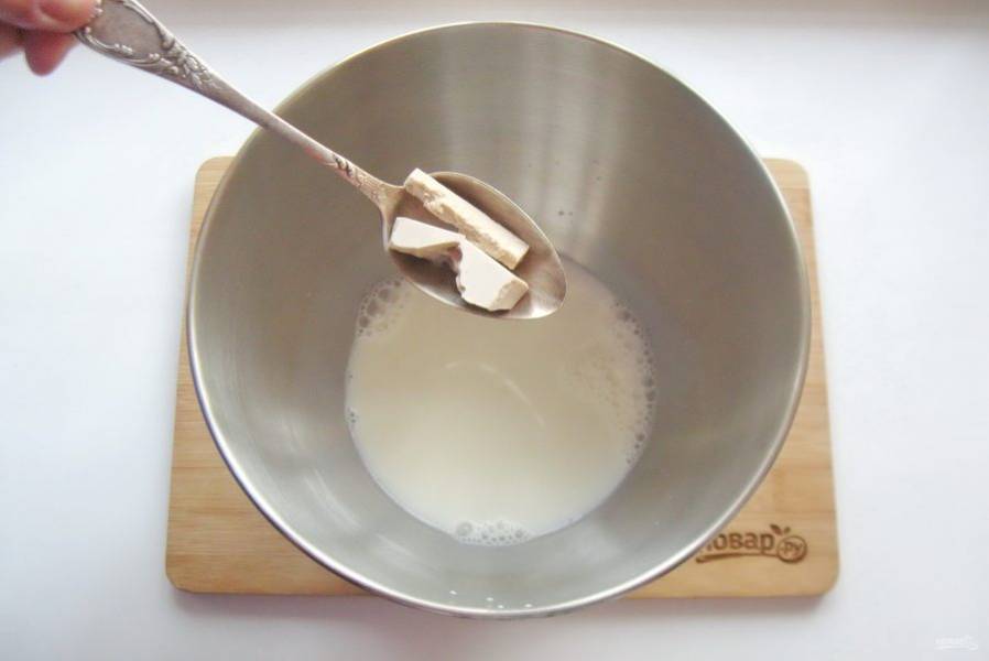 Теплое молоко налейте в миску или в чашу миксера. Добавьте дрожжи.