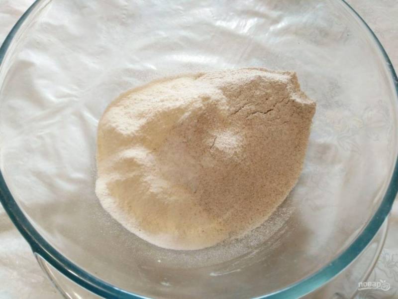 В глубокую миску просейте два вида муки (ржаную и пшеничную), добавьте соль и разрыхлитель, перемешайте.