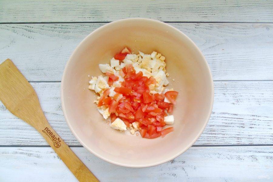 Яйца сварите вкрутую, охладите, очистите и нарежьте. Добавьте нарезанные помидоры.