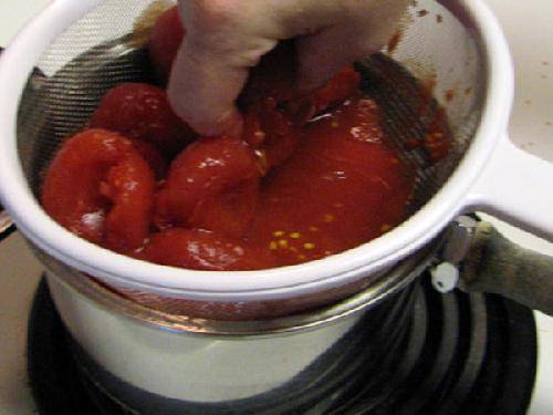 Выдавите, процедите помидоры над кастрюлей. 