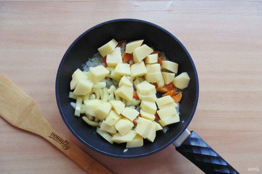 И нарезанный кубиками картофель. Налейте 100 мл. воды. Накройте сковороду крышкой и тушите овощи до готовности.