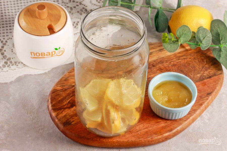 Выложите лимонную нарезку в кувшин или в глубокую стеклянную емкость.