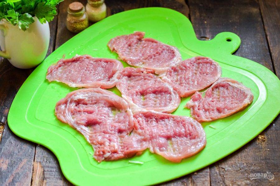 Мясо нарежьте небольшими кусочками, после прикройте его пищевой пленкой и отбейте кухонным молотком.