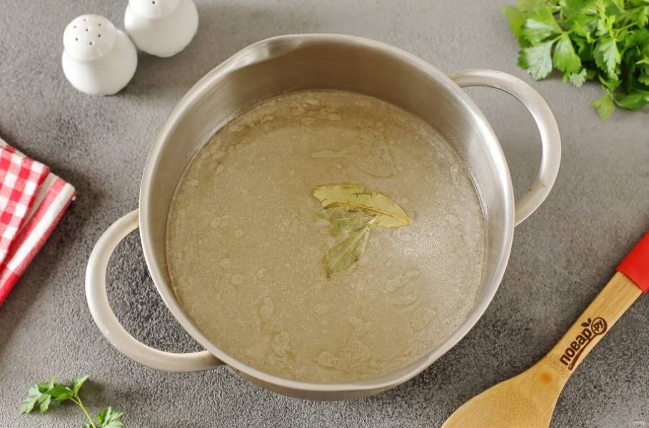Налейте в кастрюлю воду или любой мясной бульон, добавьте лавровый лист и доведите до кипения.