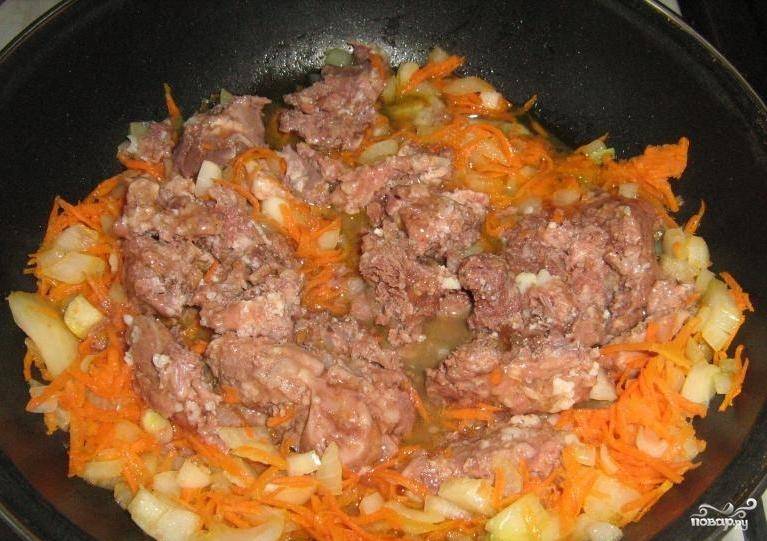 Далее выложим на сковородку тушенку, разровняем ее по всей сковородке и добавим нарезанный картофель. 