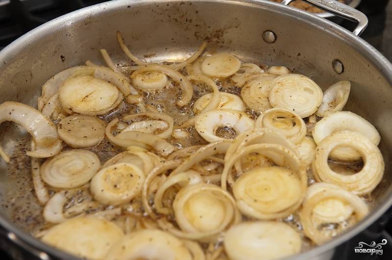 На этой же сковороде, на среднем огне растапливаем 3-4 ложки сливочного масла. Добавляем и обжариваем лук до золотистого цвета.
