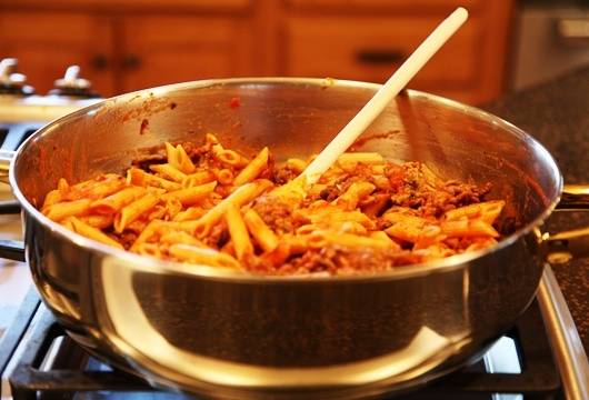 Макароны также откидываем на дуршлаг и перекладываем их в глубокую кастрюлю, добавляем фарш, соус для спагетти, половину пармезана, соль и перец по вкусу, перемешиваем все и прогреваем, чтобы сыр расплавился. 