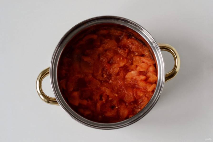 Снимите кожицу у томатов, удалите семена. Нарежьте помидоры кубиками. Переложите в кастрюлю и варите на среднем огне 15 минут. 