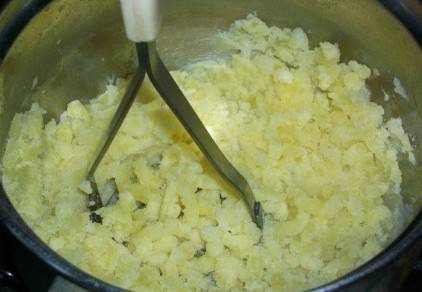 Картофель сварился. Сливаем с него воду, солим и добавляем молоко. Разминаем в пюре.