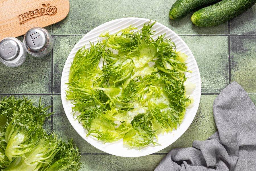 Салатные листья порвите руками на кусочки среднего размера. Выложите в тарелку для подачи.