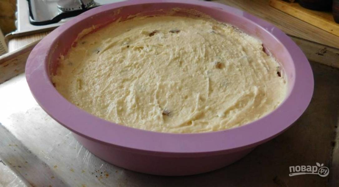 Изюм заливаем кипятком на 10 минут. Затем просушиваем его и отправляем в тесто вместе с цедрой, мукой и разрыхлителем. Вымешиваем тесто и отправляем в форму для выпечки, смазанную маслом.
