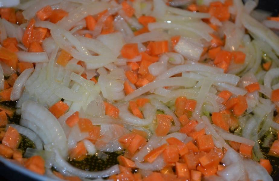 Полукольцами нарезаем лук и мелкими кубиками морковь. Обжариваем все на растительном масле, постоянно перемешивая.